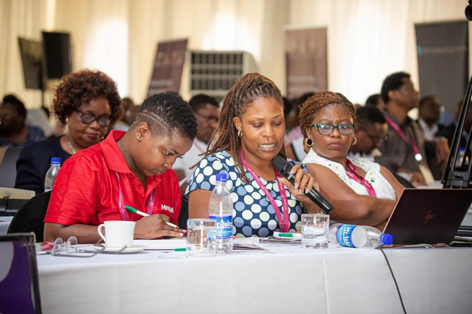 Delegates taking notes during a conference session