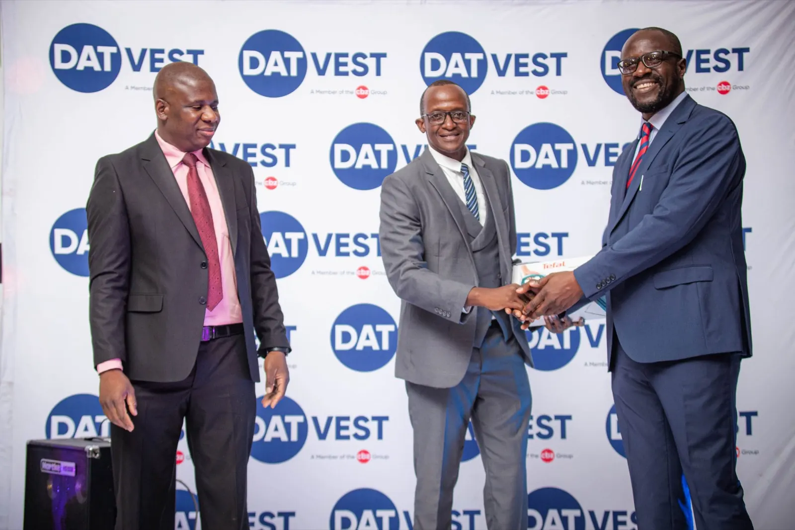 Industry partners shake hands during an award presentation